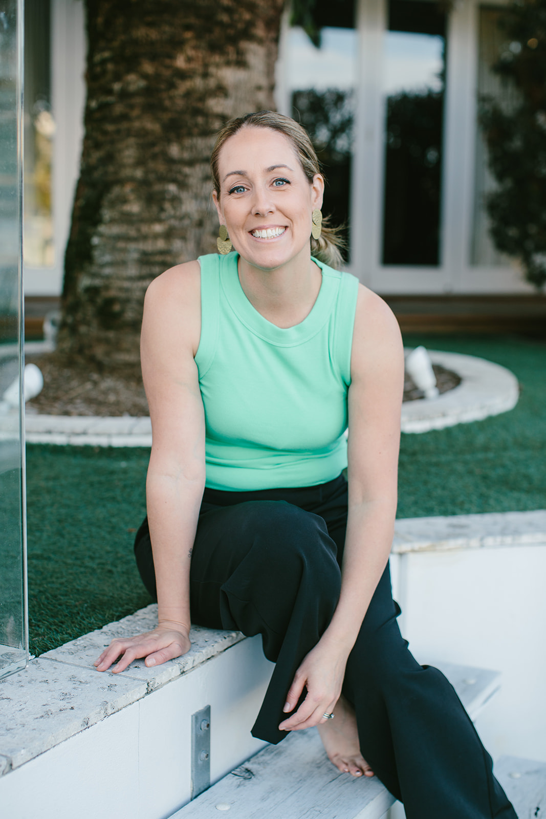 Robyn sitting on the steps in her garden, smiling at the camera